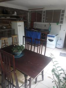 eine Küche mit einem Holztisch mit Stühlen und einem Tisch in der Unterkunft Casa dos corais in Vila Velha