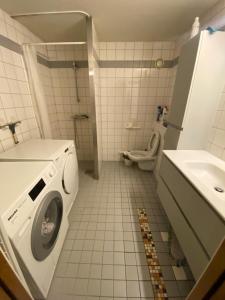 a bathroom with a washing machine and a toilet at Guesthouse - Oslo Centrum in Oslo