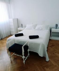 a bedroom with a white bed with two pillows on it at Casa de Mirtha in Madrid