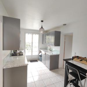 a kitchen with white cabinets and a counter top at Le Cocon Céleste à Longjumeau in Longjumeau