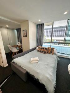 a bedroom with a large bed with a large window at Cozy Chic Haven: Modern Comfort in Gold Coast