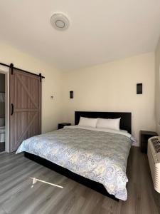 a bedroom with a large bed and a wooden floor at City Centre Motel II in Hope