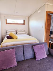 ein Schlafzimmer mit einem Bett und zwei lila Kissen in der Unterkunft Cabaña Bulnes in Puerto Natales