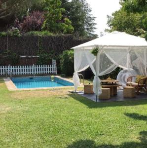 uma tenda branca num quintal com piscina em Casa de Mirtha em Madri