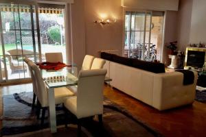a living room with a white couch and a glass table at Casa de Mirtha in Madrid