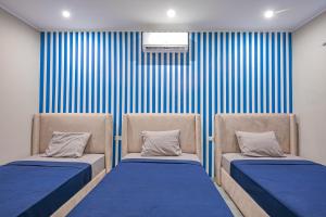 two beds in a room with blue and white stripes at Bedcoin Hostel in Hurghada