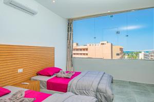 een slaapkamer met 2 bedden en een groot raam bij Bedcoin Hostel in Hurghada