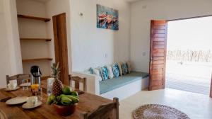 a dining room with a table and a couch in a room at Casa da Duna in Tatajuba