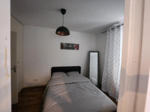 - une chambre avec un lit et un miroir mural dans l'établissement F2 proche de La Defense, à Courbevoie