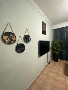 a living room with a tv on a white wall at Amazing studio Φωλιά in Xanthi - myHomee in Xanthi
