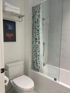 a bathroom with a toilet and a shower curtain at Brand new 1Queenbed family suite near UBC in Vancouver