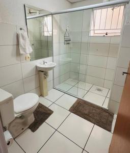 a bathroom with a shower and a toilet and a sink at Apartamento inteiro Varzea Grande MT in Várzea Grande