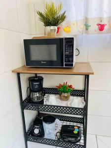 a microwave sitting on top of a shelf at Apartamento inteiro Varzea Grande MT in Várzea Grande