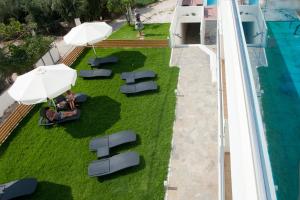 an overhead view of a pool with lawn chairs and umbrellas at Aestas Apartments in Agia Marina Nea Kydonias