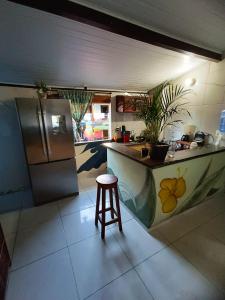 a kitchen with a counter and a stool in it at Hostel Alto Astral - Fonte in Morro de São Paulo