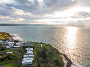an aerial view of a house on a hill next to the ocean at NRMA Portland Bay Holiday Park in Portland