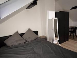 una camera da letto con un letto con cuscini sopra di Quality Suites - Proche Versailles Paris - Parking Gratuit a Saint-Germain-en-Laye