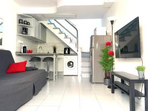 a living room with a couch and a kitchen at Bungalow Helena in Maspalomas