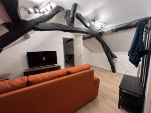 a living room with a couch and a tv at Quality Suites - Proche Versailles Paris - Parking Gratuit in Saint-Germain-en-Laye