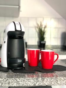 a coffee maker and two red cups on a counter at Bungalow Helena in Maspalomas