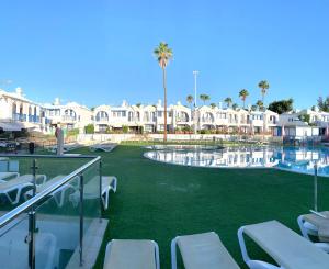 a resort with a swimming pool with lawn chairs at Bungalow Helena in Maspalomas