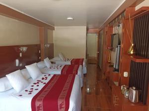 a hotel room with two beds and a television at Hs Tierra In in Machu Picchu