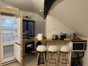 a kitchen with a counter with stools in it at Quality Suites - Proche Versailles Paris - Parking Gratuit in Saint-Germain-en-Laye