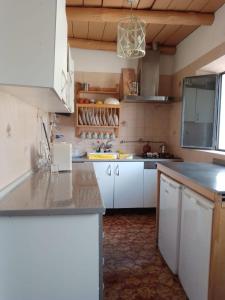 a kitchen with white cabinets and a counter top at La casita en la Alcornocosa -Sevilla in Seville