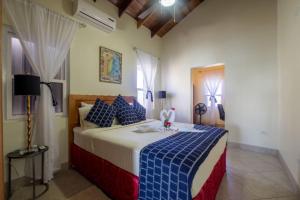 Un dormitorio con una cama grande con sábanas azules y blancas. en La Perla Azul Beach House with Pool and 4 seater cart, en San Pedro 66 fotos más