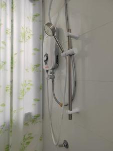 a shower head in a bathroom with a shower curtain at STUDIO SUITE HOMESTAY KLIA in Sepang
