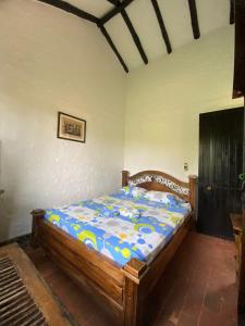 ein Schlafzimmer mit einem Holzbett in einem Zimmer in der Unterkunft CASA CAMPESTRE LA CAMPIÑA LA VICTORIA Valle del Cauca ESPACIO COMPLETO-desayuno a pareja in Matazarza