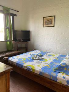 una camera da letto con un letto con un piumone colorato di CASA CAMPESTRE LA CAMPIÑA LA VICTORIA Valle del Cauca ESPACIO COMPLETO-desayuno a pareja a Matazarza