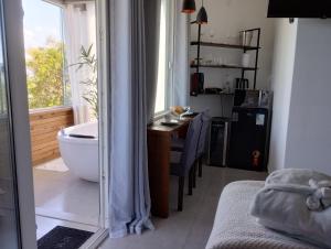 a room with a bathroom with a tub and a desk at North Suíte in Florianópolis