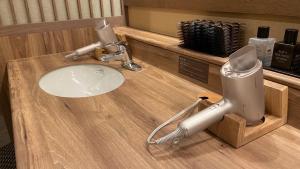 a hair dryer sitting on top of a bathroom sink at Onyado Nono Matsumoto Natural Hot Spring in Matsumoto