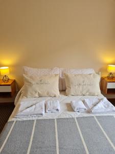 1 cama con sábanas blancas y almohadas en una habitación en Aires de Montaña - Departamento en Los Penitentes, Mendoza en Los Penitentes