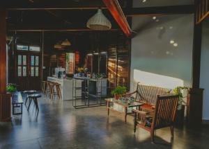 uma sala de estar com cadeiras e uma mesa e uma cozinha em Elon Coffee Farmstay em Da Lat