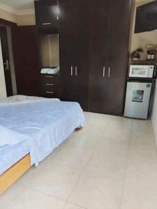 a bedroom with a large bed and a kitchen at Casafrancesbqte in Boquete