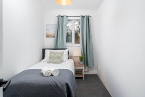 a bedroom with a bed with two towels on it at Skyvillion - COZY House in Rochester, Kent- 3 Bed with Garden, WiFi & Parking in Rochester