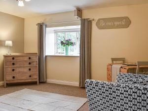 a living room with a window and a dresser at Daisys Dairy in Bishops Lydeard