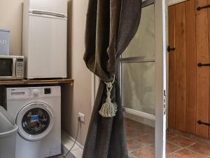 a laundry room with a washing machine and a window at Daisys Dairy in Bishops Lydeard