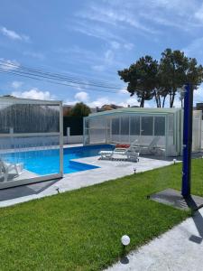 una casa con piscina y un edificio en Aroeira Tropical Villa, en Charneca