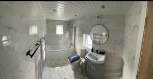 een badkamer met een wastafel, een toilet en een bad bij THE SOUTH VALLEY HOME in Neath