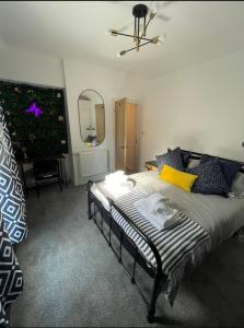 een slaapkamer met een groot bed met een spiegel en een piano bij THE SOUTH VALLEY HOME in Neath