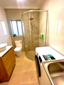 a bathroom with a shower and a sink and a toilet at Victor Seaside Villa in Victor Harbor
