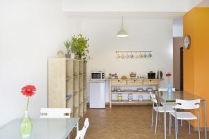 a kitchen with a table and chairs and a refrigerator at B&B La Gatta Bianca in Oliveri