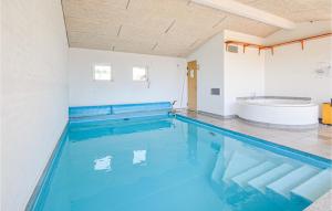 a large swimming pool with a tub in a room at Awesome Home In Ebeltoft With 4 Bedrooms, Sauna And Wifi in Ebeltoft