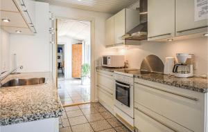 エーベルトフトにあるAwesome Home In Ebeltoft With 4 Bedrooms, Sauna And Wifiの白いキャビネットとシンク付きのキッチン