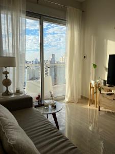 a living room with a couch and a large window at Departamento moderno con vistas al rio Paraná. in Corrientes