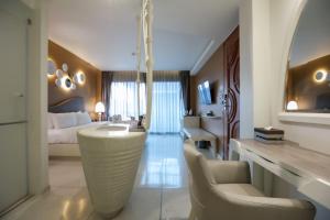 a bedroom with a bed and a living room at Rachabhura Hotel in Ratchaburi