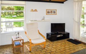 sala de estar con silla y TV en Cozy Home In Hals With Kitchen, en Hals
